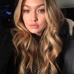 Selfie of a pretty woman (Gigi Hadid) with long blonde wavy hair and natural makeup.
