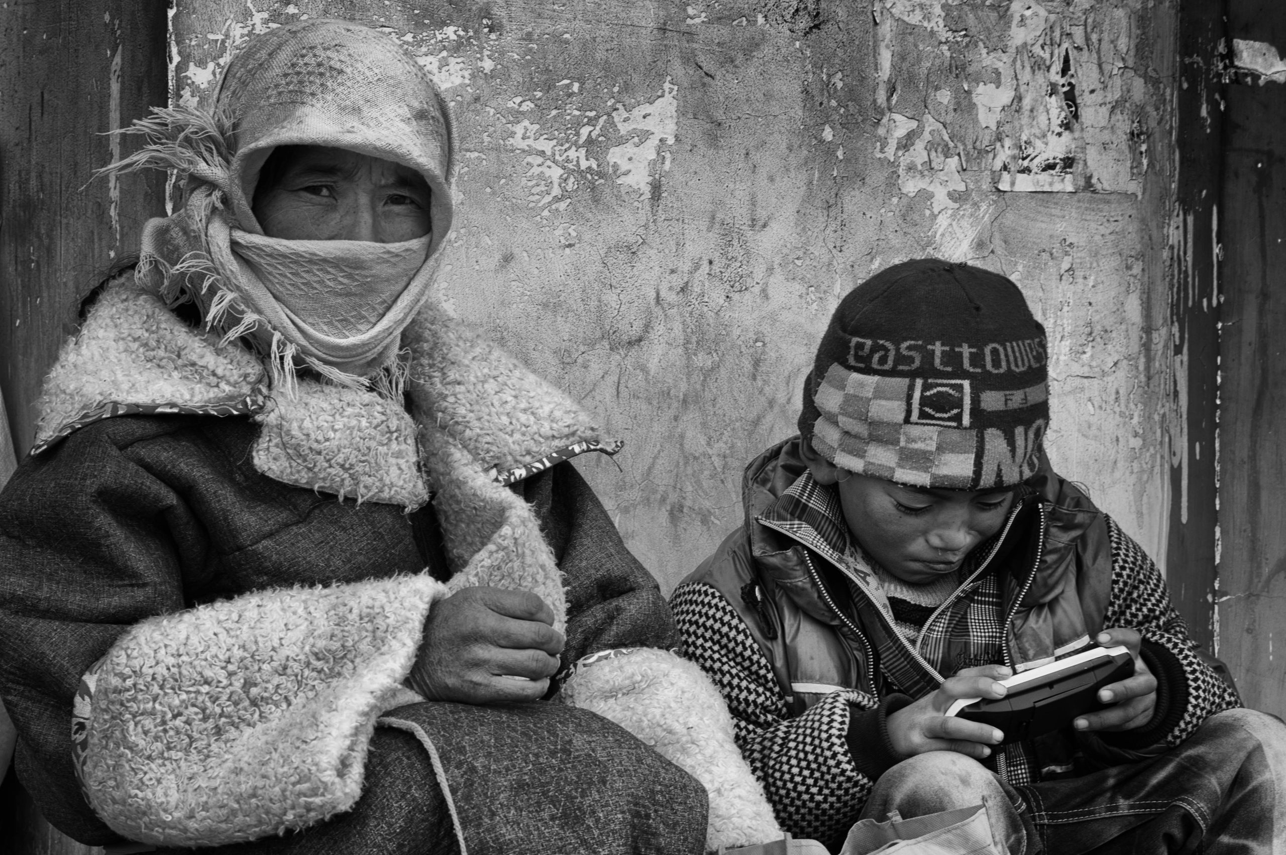 Black and white photo of Tibetan mother and boy child sitting in winter clothes