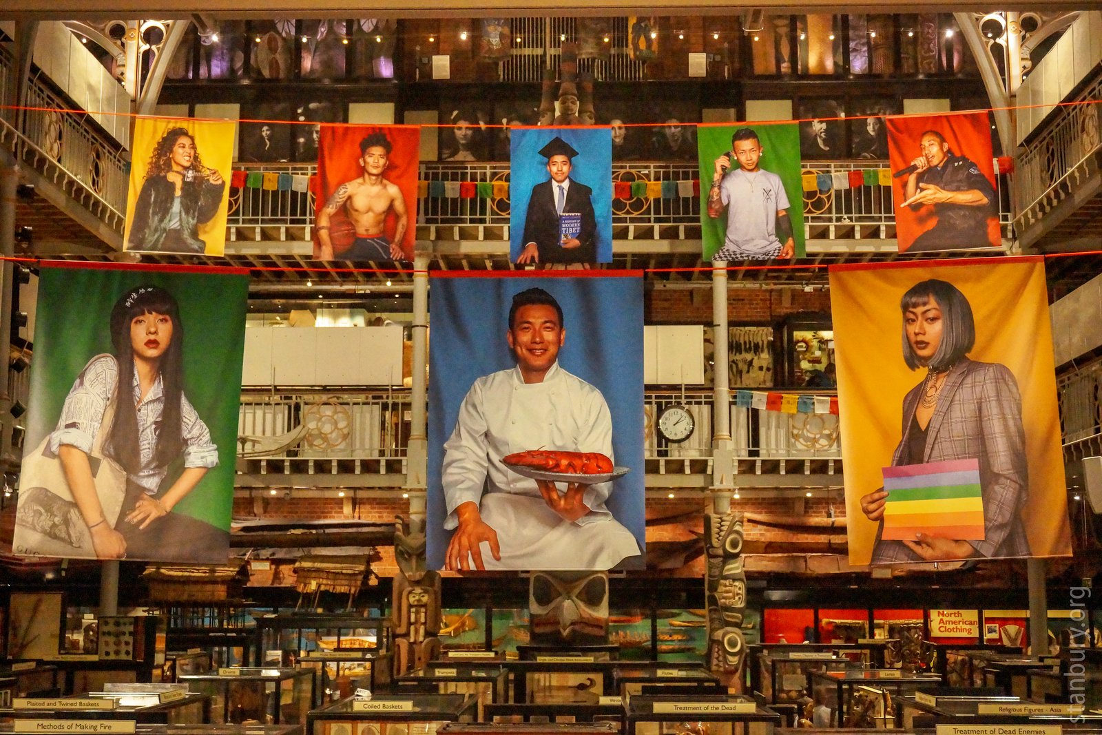 Portraits of various Tibetan people on banners. One is a chef, one is a singer, one has an LGBT flag, one is a graduation portrait, etc.