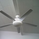 A white fan hanging from a ceiling