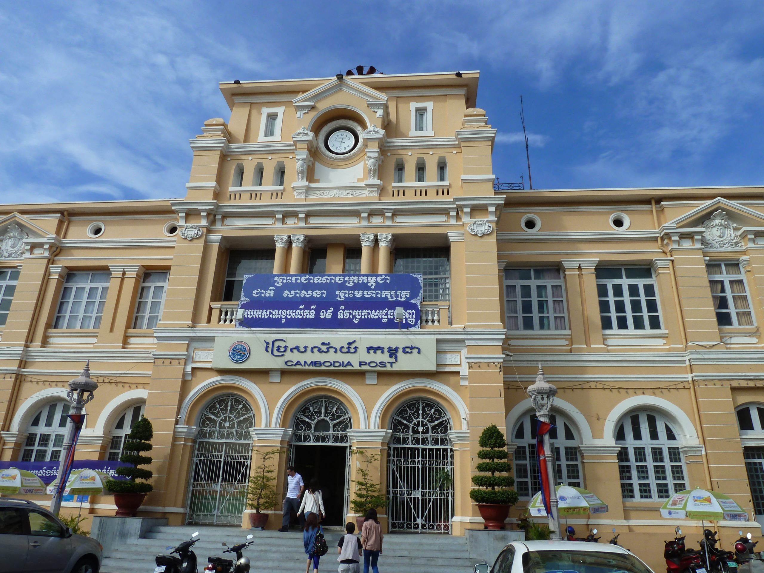 A large building with Khmer language and the words Cambodia post on the front