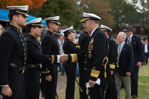 US navy superintendent of navy academy shakes hands of brigade leadership in formal parade
