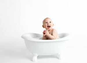 a baby sitting in a little white bath tub