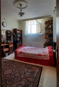One bedroom studio in Iran, a single bed by the window with bookshelves in both side