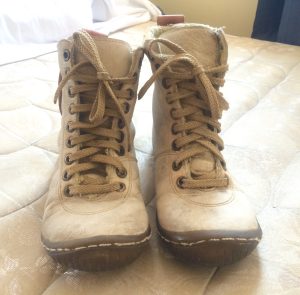 pair of cream color boots on the bed